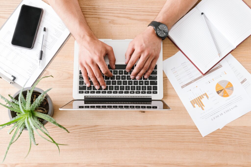 Cropped image from above of caucasian businessman sitting at tab